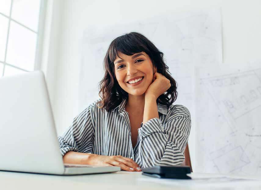 woman with her laptop on smiling at the camera